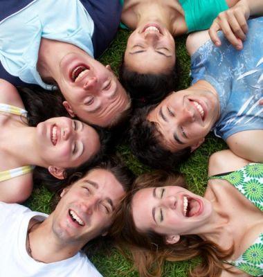 Les bienfaits du rire avec Eclat de toi: groupe de personnes couchées en cercle tête contre tête qui rient suite à un atelier du rire